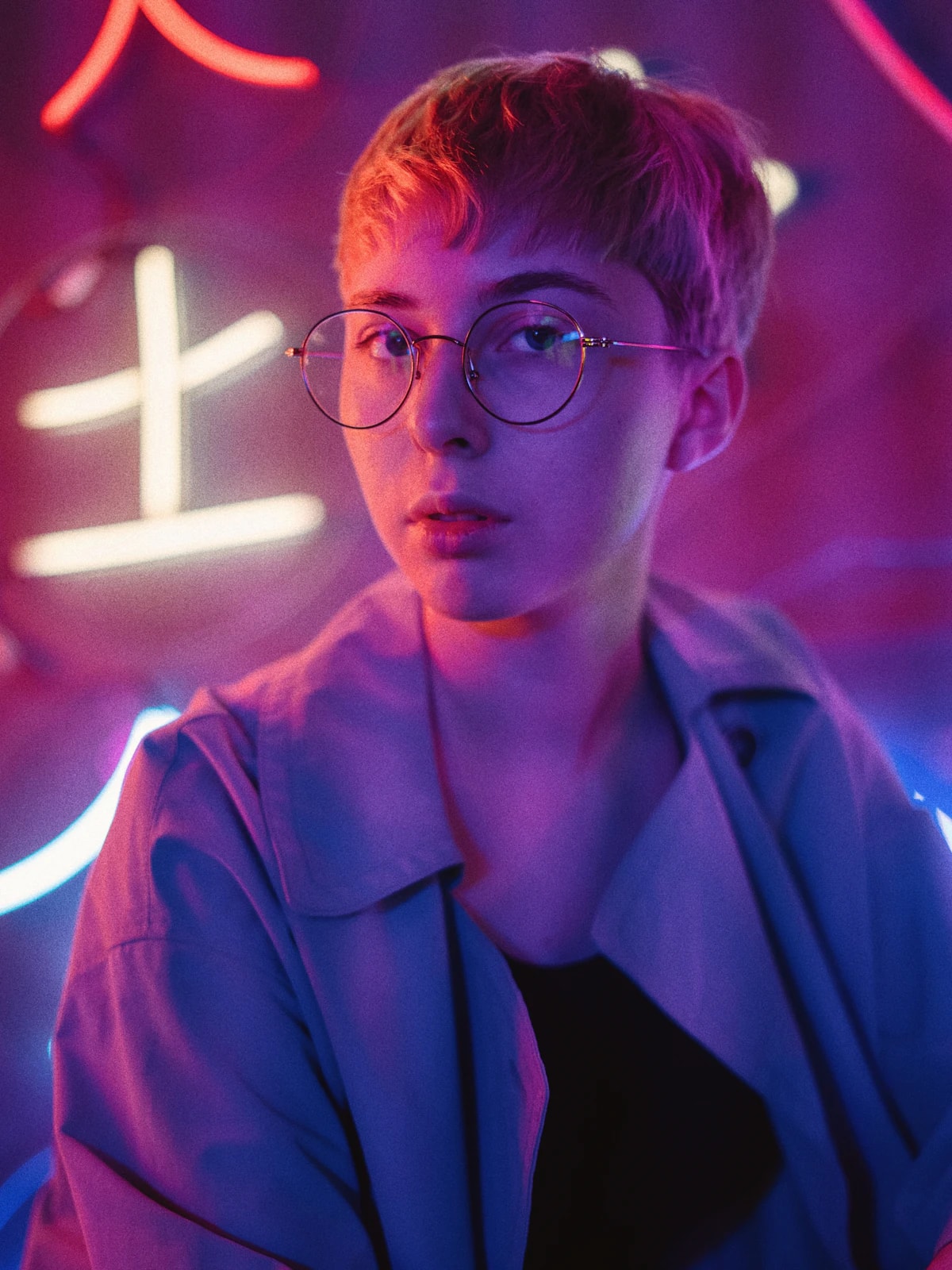 Bărbat cu ochelari, în lumină roz de neon